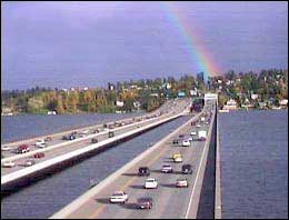 Photo: cars on a two-span bridge in Washington with a rainbow in the background