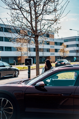 Woman Charging Porsche Taycan with Juice Station
