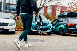Man Carrying Juice Cable to Car