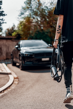 Man Carrying Juice Cable to Car