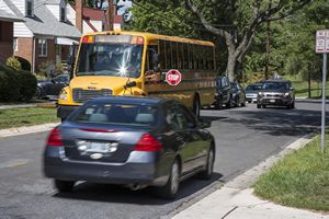 Car Passing School Bus with Stop Sign Out