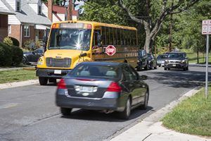 Car Passing School Bus with Stop Sign Out
