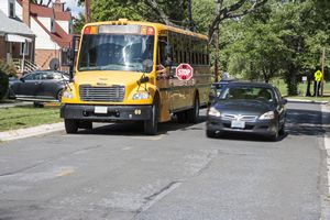Car Passing School Bus with Stop Sign Out